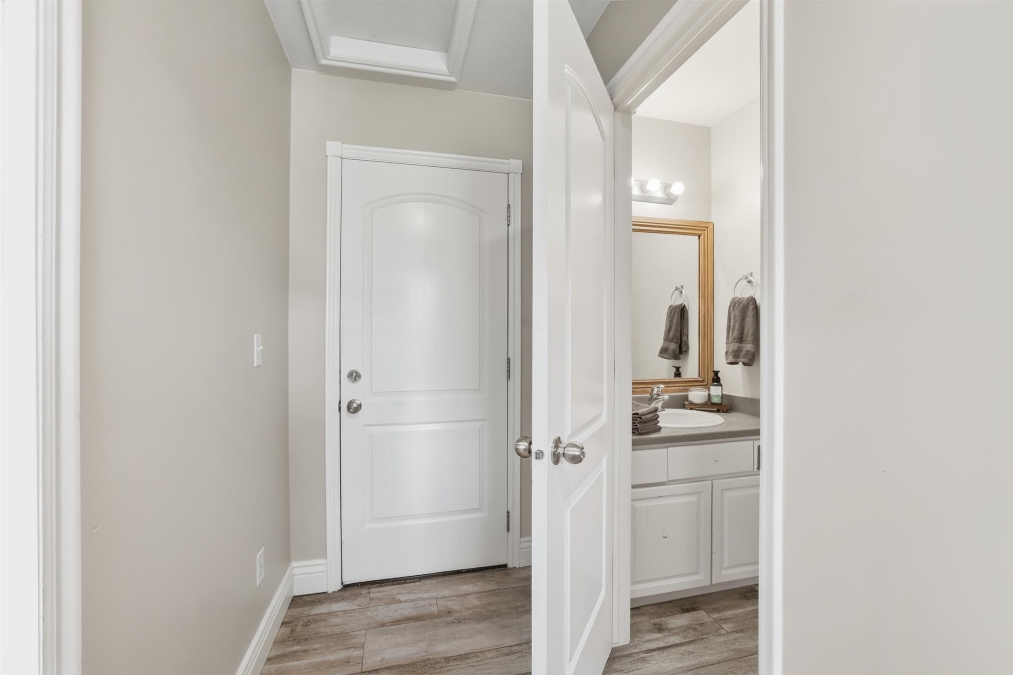 Contemporary bathroom with a single vanity, undermount sink, and wood-finish flooring