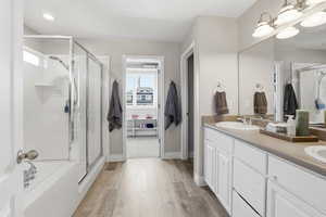 Bathroom featuring a double vanity with integrated sinks, a large mirror, and overhead vanity lighting