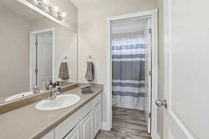 Bathroom vanity featuring an integrated oval sink, brushed nickel faucet, and a large wall-mounted mirror with a four-bulb vanity light fixture