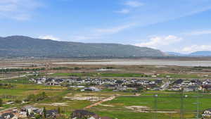 Expansive landscape featuring distant mountains, a body of water, and residential developments