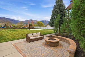 Paver patio with a built-in fire pit and a coordinating curved retaining wall