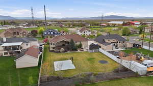 Expansive green lawn with mature landscaping, featuring a built-in sports court and a privacy fence