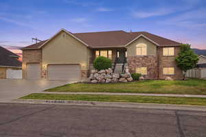 Multi-level residence featuring a stone and stucco exterior, a two-car garage, and an additional single-car garage