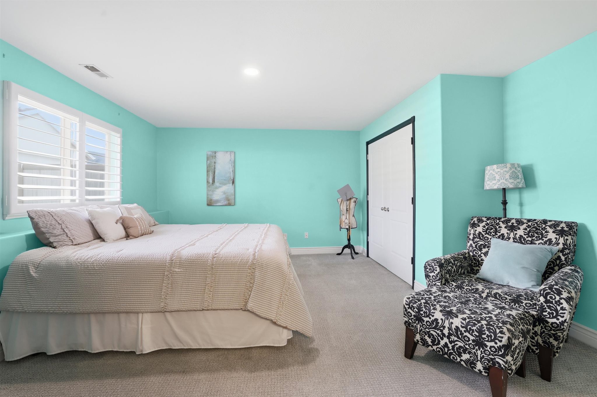 Carpeted room with a recessed light, dual windows with white plantation shutters, and a white bi-fold closet door