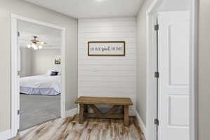 Inviting entryway featuring wood-finish flooring, a decorative shiplap accent wall, and a rustic wooden bench