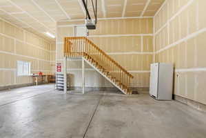 Spacious garage interior featuring unfinished walls, a concrete floor, and an exposed ceiling