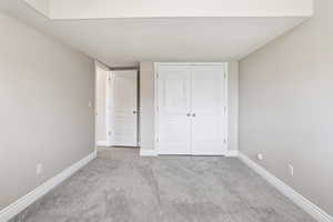Neutral-toned walls complement plush grey carpeting