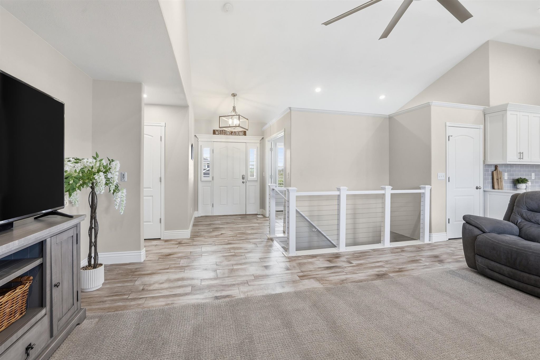 Open concept living space featuring wood-finish flooring, vaulted ceilings, and recessed lighting