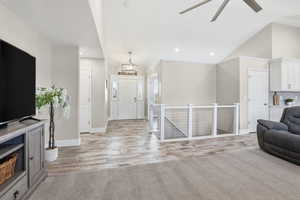 Open concept living space featuring wood-finish flooring, vaulted ceilings, and recessed lighting