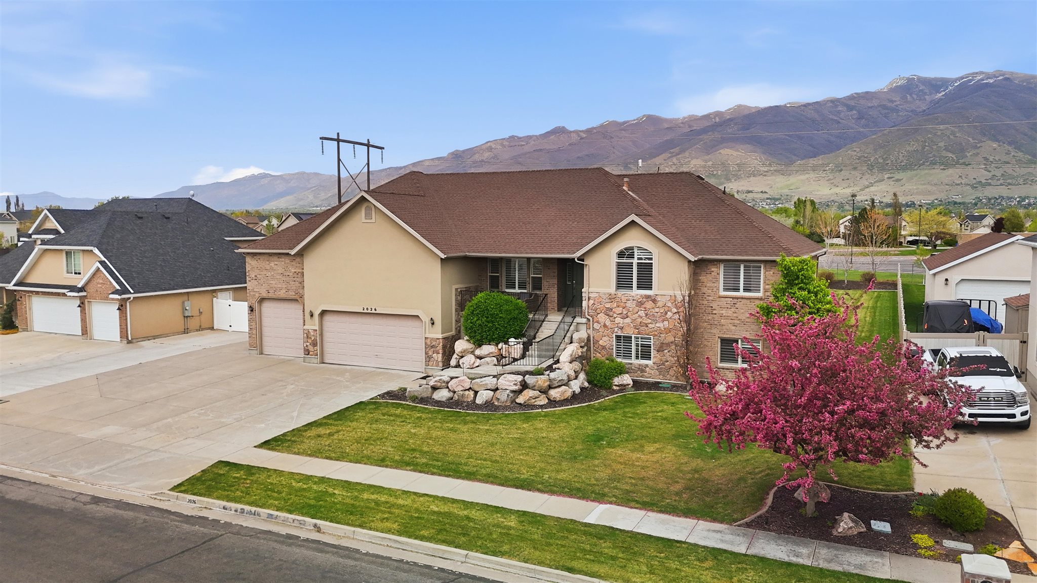 Two-story residence featuring a brick and stucco exterior, a prominent front lawn, and an attached two-car garage