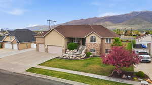 Two-story residence featuring a brick and stucco exterior, a prominent front lawn, and an attached two-car garage