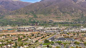 Expansive neighborhood with diverse residential architecture and commercial areas, set against a backdrop of prominent mountains