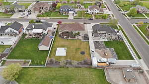 Expansive backyard featuring a large green lawn, distinct patio space, a dedicated play area with equipment, a trampolene, and mature perimeter landscaping