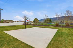 Recreational concrete pad with an adjustable basketball hoop, surrounded by green lawn