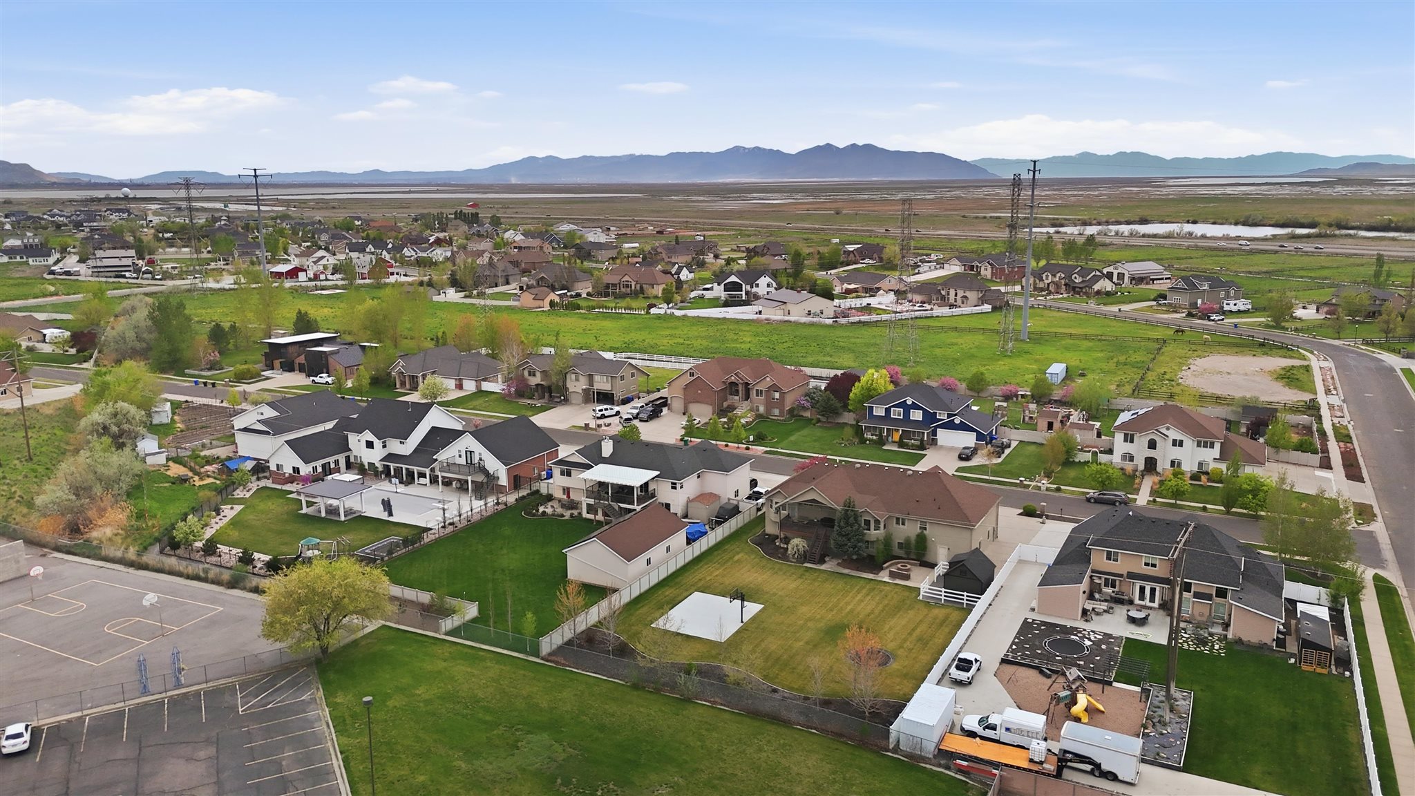 Residential neighborhood featuring a variety of single-family homes with diverse architectural styles, surrounded by green spaces and distant mountains