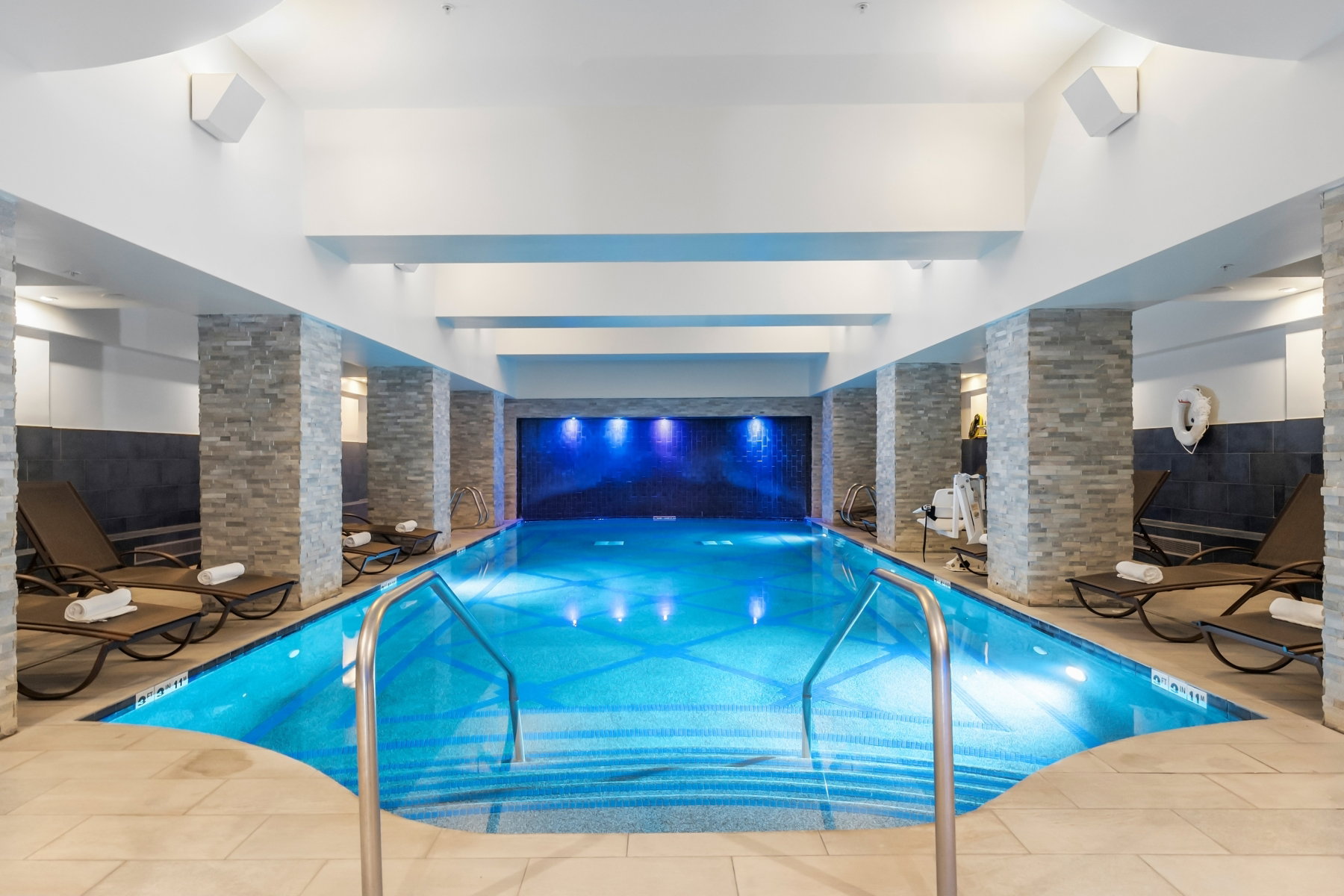 Indoor swimming pool with mosaic tile and blue accent lighting