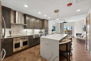 Kitchen featuring dark wood cabinetry, stainless steel appliances, and a mosaic tile backsplash