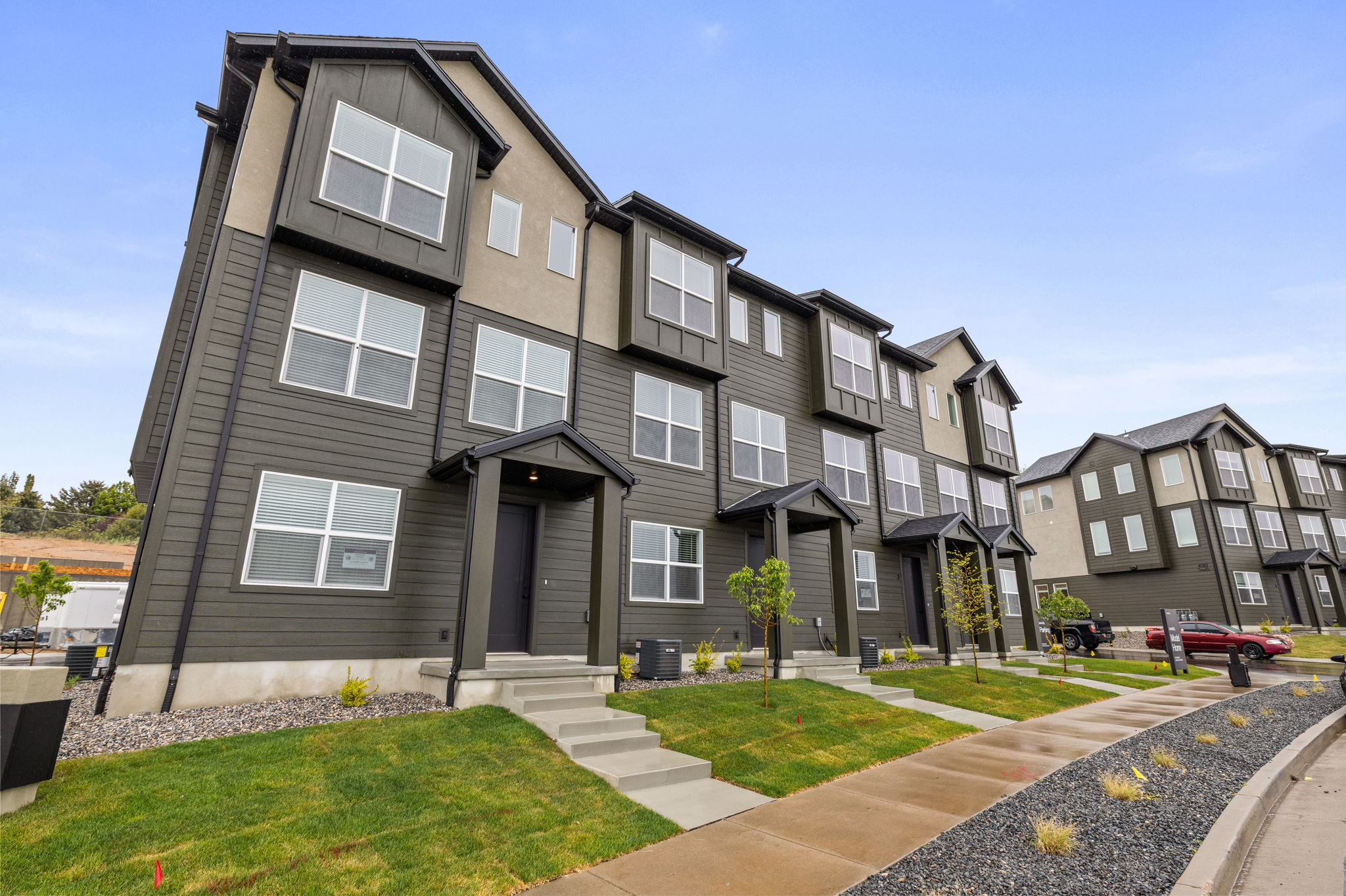 Modern townhome featuring a dark gray siding and light stucco exterior