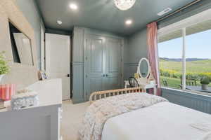 Bedroom featuring a large window, providing expansive views of the outdoor landscape