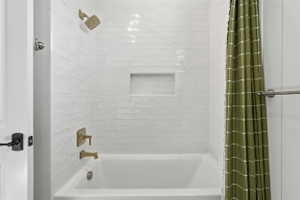 White subway tile shower surround featuring a built-in niche