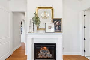 White-mantled fireplace in primary suite featuring a glass-front insert and decorative hearth