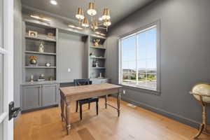 Dedicated workspace featuring built-in shelving, cabinetry, and a desk area