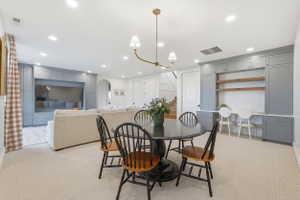 Recessed lighting illuminates this versatile space featuring light-toned carpeting and built-in work space