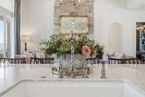 White farmhouse sink with a polished nickel bridge faucet, set into a light-colored marble countertop