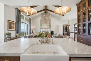 Expansive kitchen island with a farmhouse sink and marble countertops looking into the great room