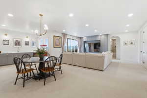 Spacious open-concept room with light carpeting, recessed lighting, and a built-in entertainment center featuring Portsmouth blue cabinetry