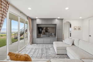 Recessed lighting illuminates a built-in entertainment center with extensive cabinetry and shelving