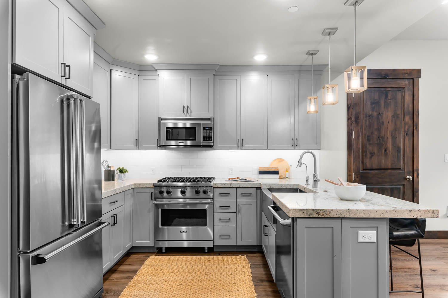 Kitchen featuring light grey cabinetry with dark hardware, stainless steel appliances, and a gas range