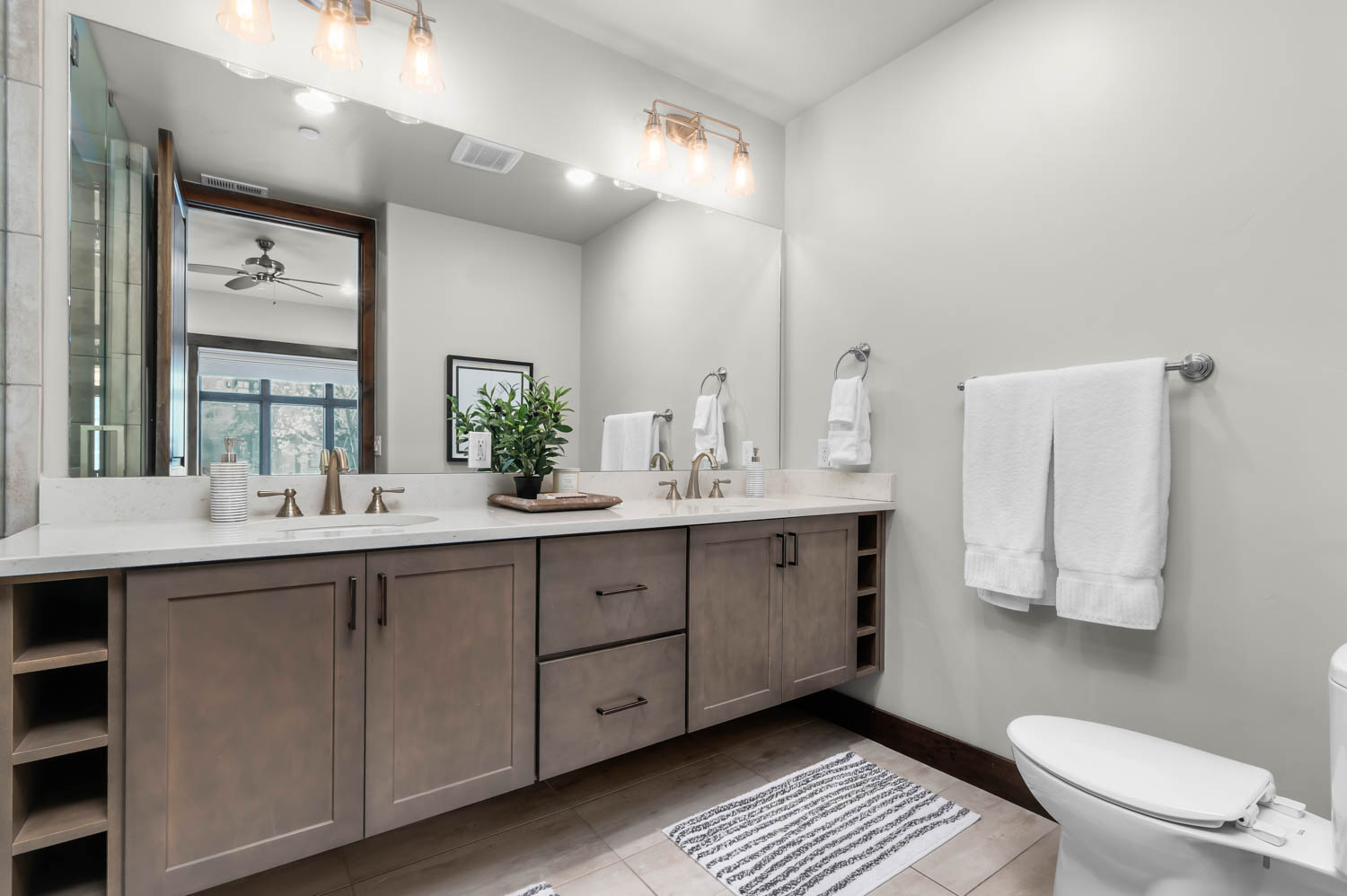 Dual vanity with light-toned cabinetry, integrated shelving, and undermount sinks