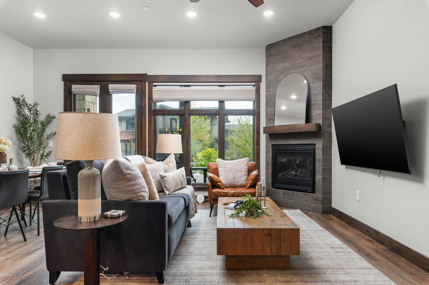 Living area featuring wood-finish flooring and a corner fireplace with a dark tile surround and wood mantel