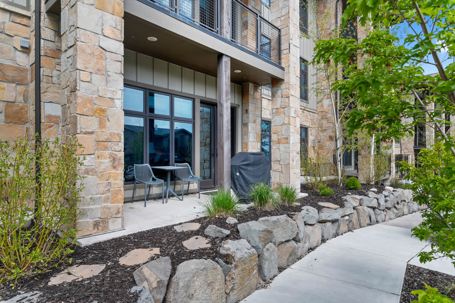 Ground-level patio with stone veneer facade