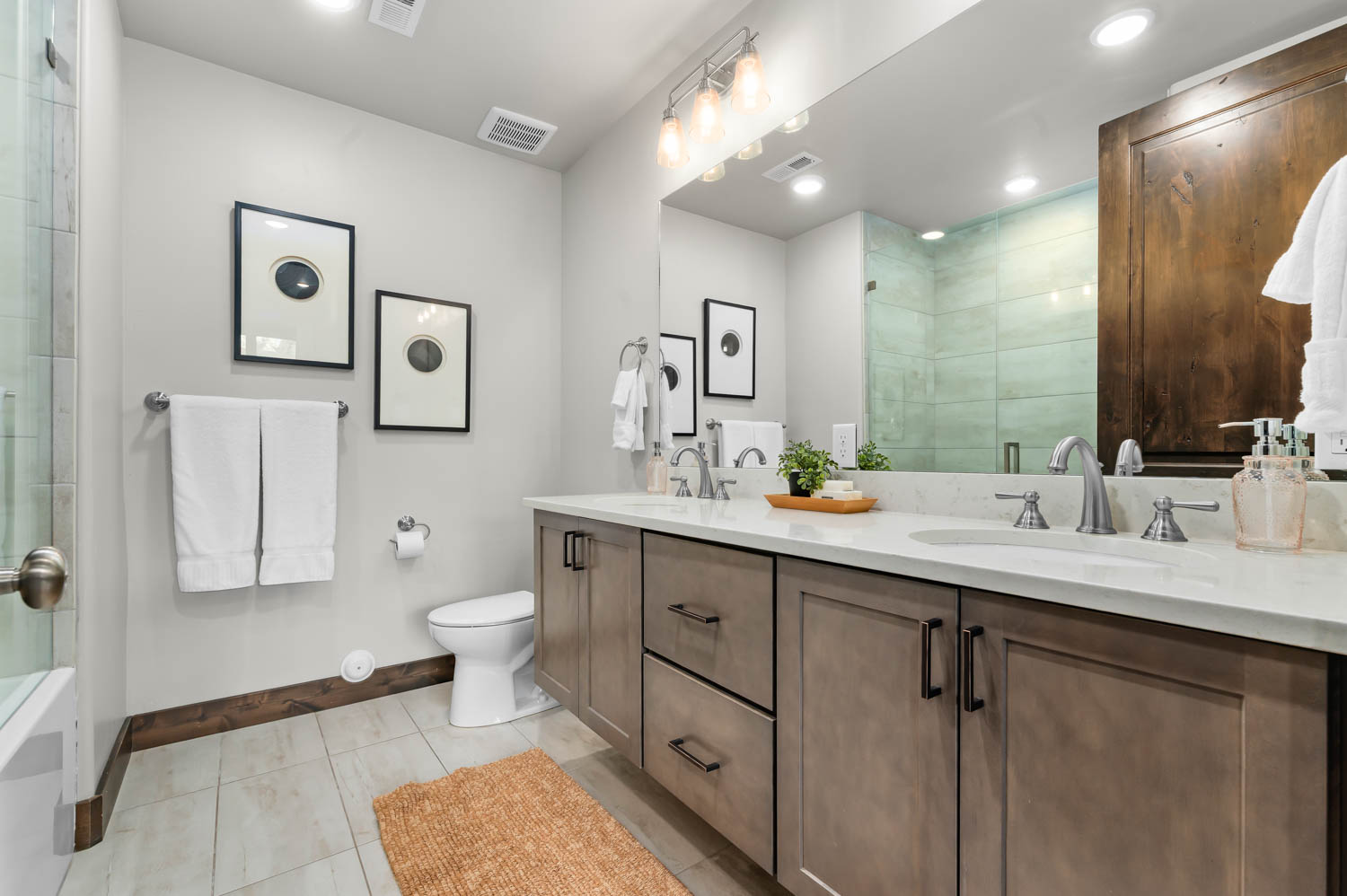Bathroom featuring a dual vanity with light-toned cabinetry and a white countertop