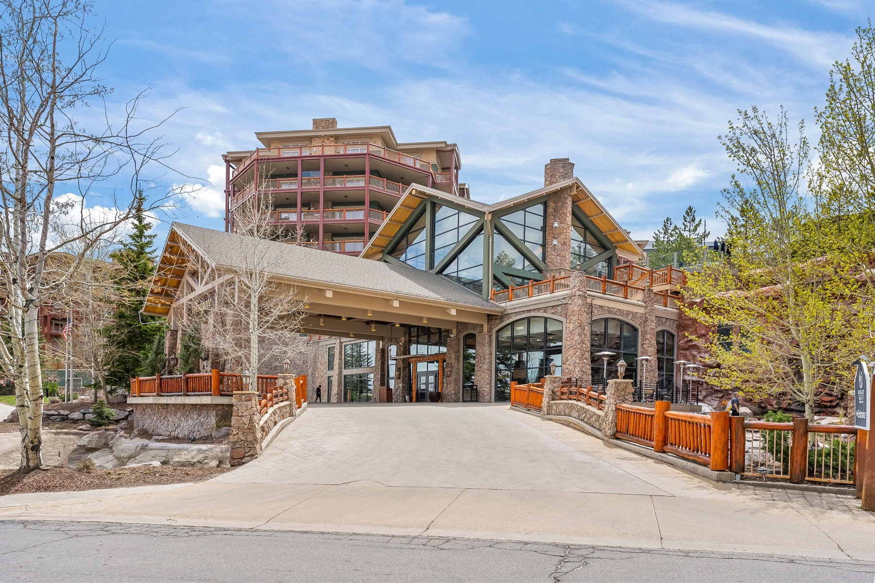 Stone and timber lodge-style building featuring a prominent covered entry