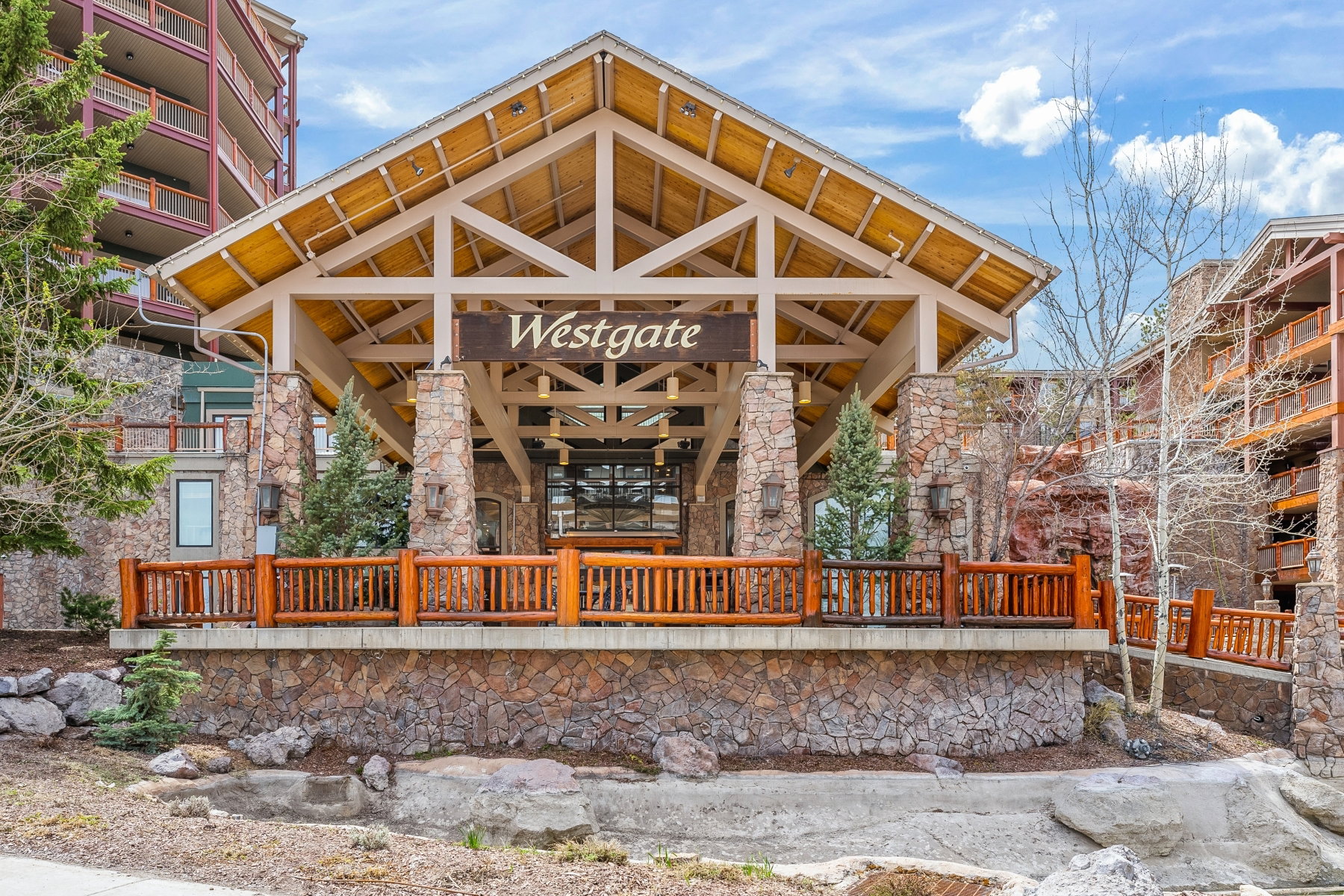 Grand lodge-style entrance featuring exposed timber framing, a prominent "Westgate" sign, and stone pillars