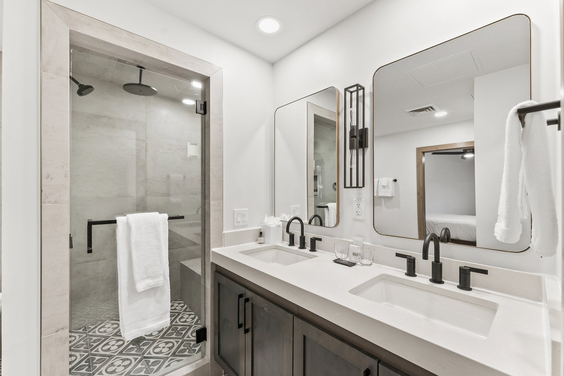 Modern bathroom featuring a dual vanity with white countertops and matte black fixtures