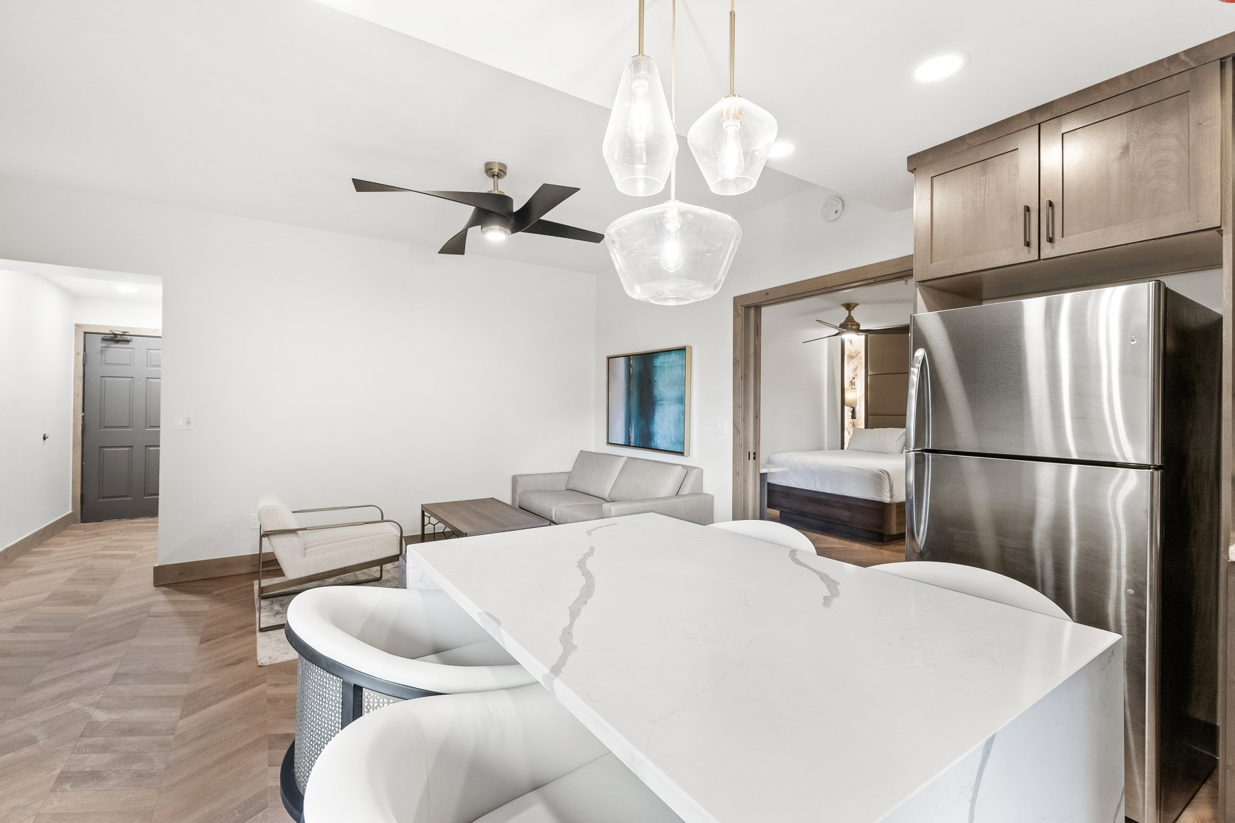 Kitchen island with a waterfall-edge countertop and integrated seating, complemented by three pendant lights
