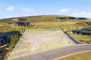 Expansive building lot with visible boundary lines, featuring a clear, level building area and paved street access