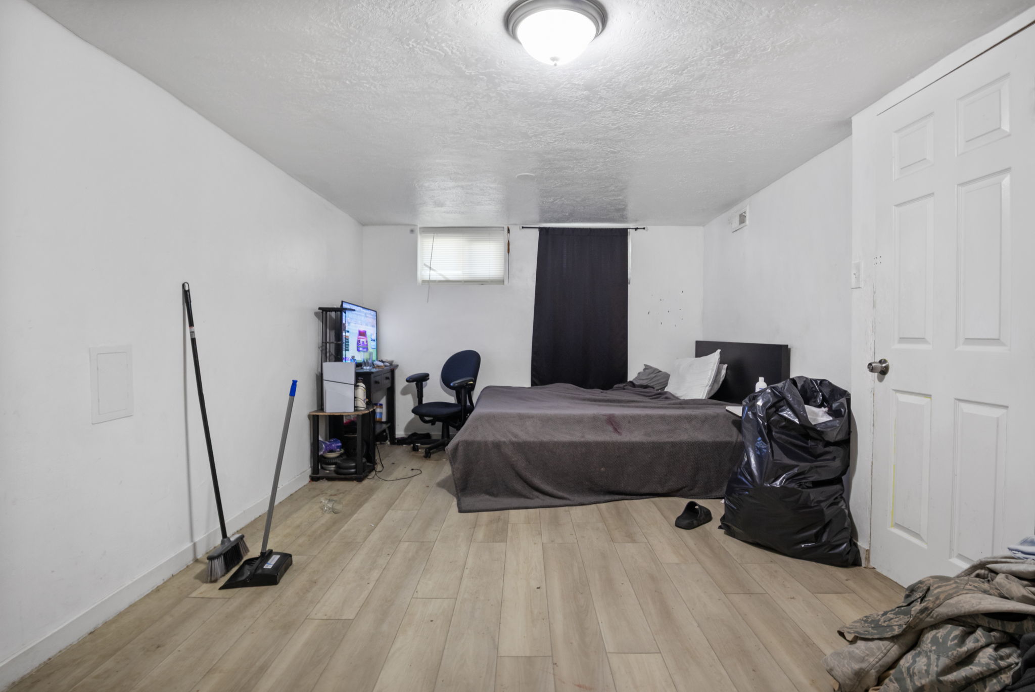 Light wood-finish flooring complements white walls in this interior space