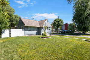 Exterior featuring light blue siding, a brown shingle roof, and multiple windows