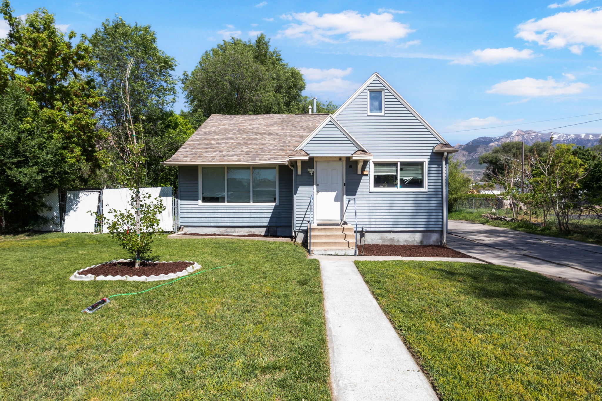 Light blue horizontal siding exterior with a contrasting white front door