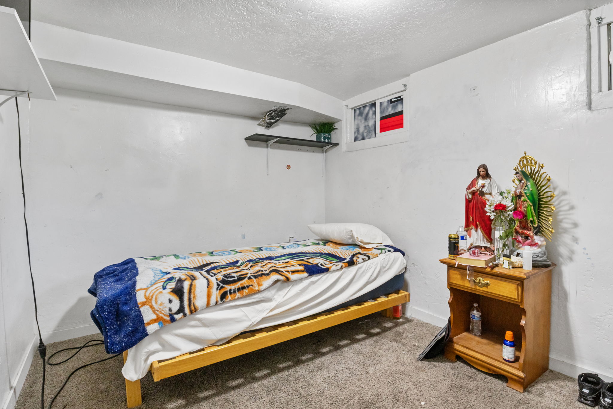 Carpeted room featuring a single window and built-in shelving