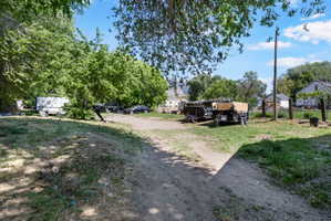 Expansive parcel featuring mature trees, a dirt path, and a partially grassed area