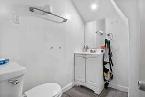 White vanity with dual cabinet storage, complemented by a wall-mounted mirror and overhead lighting