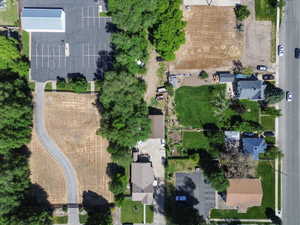 Aerial view showcasing a large, undeveloped lot with a winding paved driveway