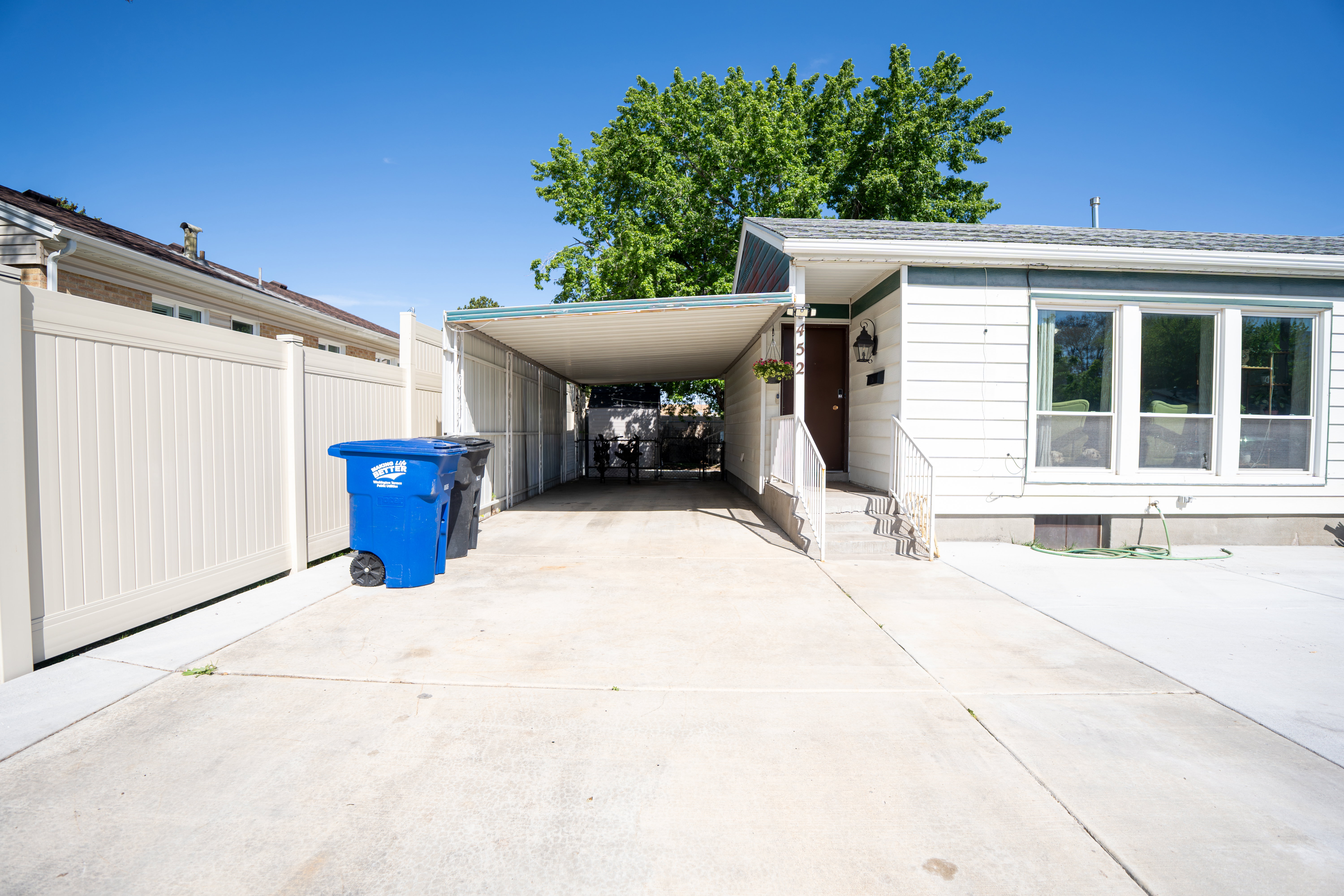 Exterior featuring a carport, concrete driveway, and white siding