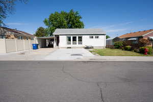 White-sided residence featuring a gray shingle roof, front-facing windows, and a concrete driveway